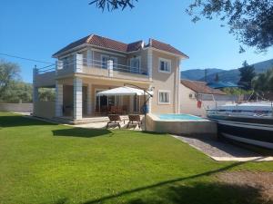 a large house with a boat in a yard at Villa Morris in Nydri