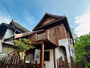 Casa de madera con porche y balcón en Villa Phonethip Mekong Riverside en Luang Prabang