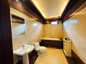 een badkamer met een wastafel, een toilet en een bad bij Villa Phonethip Mekong Riverside in Luang Prabang