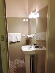 a bathroom with a sink and a mirror at Avalon Motel in Mount Gambier