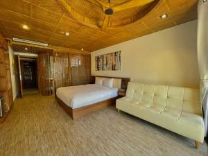 um quarto com uma cama e um sofá em LUK Inn Hotel em Da Nang