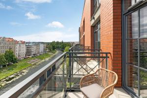 a balcony with a chair and a view of a street at Downtown Apartments Dwie Motławy Riverside & Parking in Gdańsk