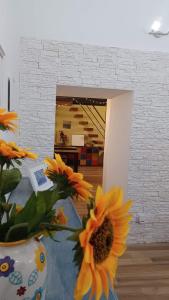 un jarrón lleno de girasoles sentado en una mesa en Rega Holiday House, en Nápoles