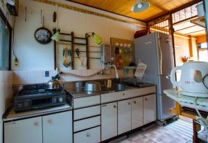 uma pequena cozinha com um lavatório e um frigorífico em Guesthouse Bon em Quioto
