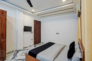een slaapkamer met een bed en een tv aan de muur bij HOTEL PLATINUM Noida 144 in Noida