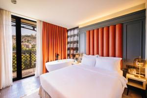 a bedroom with a large bed and a large window at Sandali Metekhi Boutique Hotel in Tbilisi City