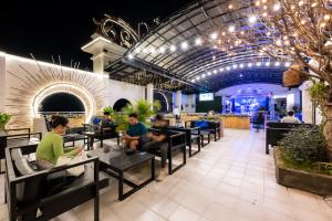 a group of people sitting at tables in a restaurant at Lbn Asian Hotel in Kampong Cham