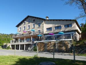 a large building with umbrellas on the balcony at Le Chalet in Antrenas
