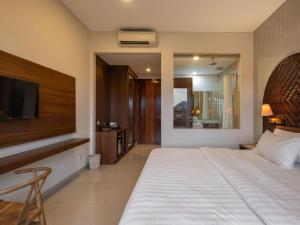 a bedroom with a large bed and a television at Cove Tevana in Seminyak +11 photos