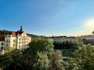 vistas a un edificio con árboles en el primer plano en Lovely large flat in historic building, balcony, parking, en Praga