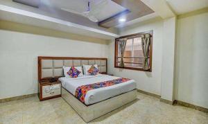 a bedroom with a large bed and a window at FabHotel Chennai Palace in Chennai