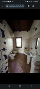 a bathroom with two sinks and a toilet at Agriturismo Sa Murta in Sennariolo