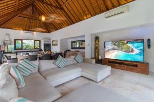 a living room with a couch and a large screen tv at Villa Bon Bon in Canggu
