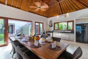 a dining room with a long wooden table and chairs at Villa Bon Bon in Canggu