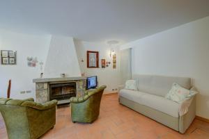uma sala de estar com um sofá e uma lareira em Villa Il Castagno Few Min From Beach - Happy Rentals em Castelveccana