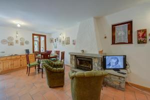 a living room with a fireplace and a tv at Villa Il Castagno Few Min From Beach - Happy Rentals in Castelveccana
