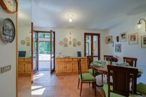 eine Küche und ein Esszimmer mit einem Tisch und Stühlen in der Unterkunft Villa Il Castagno Few Min From Beach - Happy Rentals in Castelveccana