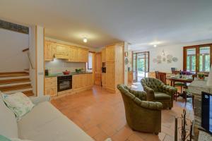 a kitchen and living room with a couch and chairs at Villa Il Castagno Few Min From Beach - Happy Rentals in Castelveccana