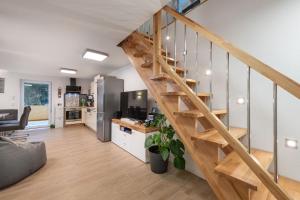 cocina y sala de estar con escalera de madera en Chalet FERIENHAUS LADERDING mit Sauna, en Bad Hofgastein