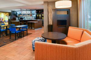 a lobby with a couch and tables and a bar at Courtyard Beaumont in Beaumont