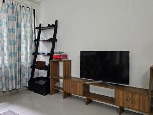 a living room with a flat screen tv on a wall at Vintage GreyRoom - Family Stay in Dhaka
