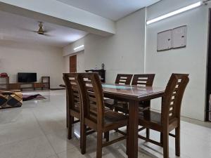 a dining room with a wooden table and chairs at Vintage GreyRoom - Family Stay in Dhaka