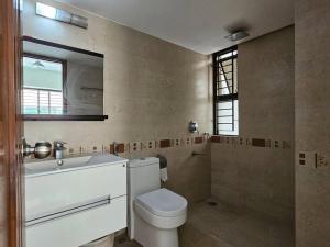 a bathroom with a toilet and a sink and a mirror at Vintage GreyRoom - Family Stay in Dhaka +70 photos