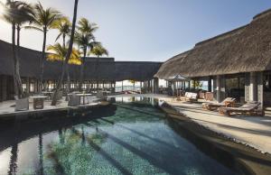 uma piscina num resort com palmeiras em Royal Palm Beachcomber Luxury em Grand Baie
