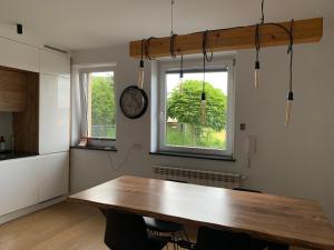 een keuken met een houten tafel en een klok aan de muur bij Dunajec Home 