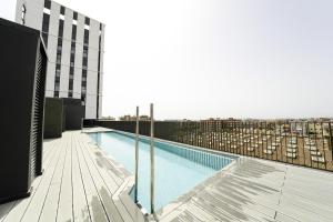 une piscine sur le toit d'un bâtiment dans l'établissement Sunsets and the pool in Barcelona, à Cornellà de Llobregat