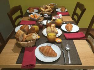 een tafel met borden croissants en brood bij Chez Michel in Bedous