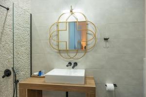 uma casa de banho com um lavatório e um espelho em Galazio Seaside Luxury Rooms & Coffee Shop em Platamon