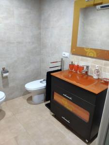 uma casa de banho com um lavatório, um WC e um espelho. em Precioso Piso+Garaje Zona Sanxenxo Grove Portovono em Pontevedra