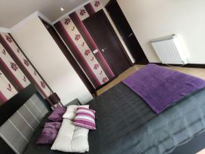 um quarto com uma cama com almofadas roxas e brancas em Precioso Piso+Garaje Zona Sanxenxo Grove Portovono em Pontevedra