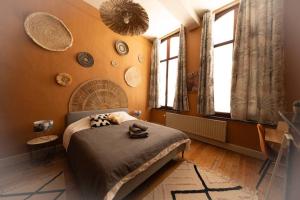 ein Schlafzimmer mit einem Bett in einem Zimmer mit Fenstern in der Unterkunft Camelia, un charme Montois in Mons