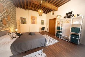 1 dormitorio con 1 cama grande y suelo de madera en Camelia, un charme Montois en Mons