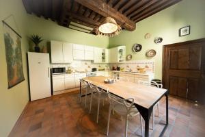 a kitchen with a table and chairs and a refrigerator at Camelia, un charme Montois in Mons