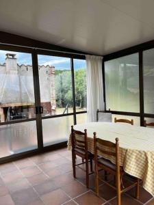 a dining room with a table and chairs and a large window at Can Catrol in Santa Cristina d'Aro