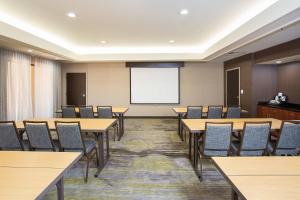 a conference room with tables and chairs and a projection screen at Courtyard by Marriott Boston Westborough in Westborough