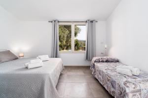 1 dormitorio con 2 camas y ventana en Domo Bonaeras, en Irgoli