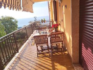 einen Balkon mit Stühlen und einem Tisch mit Blumen darauf in der Unterkunft A casa di Clo' in Sanremo