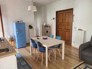 eine Küche mit einem Tisch und Stühlen sowie einem blauen Kühlschrank in der Unterkunft A casa di Clo' in Sanremo