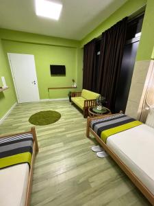a hotel room with two beds and a couch at Green Apartment in Strumica