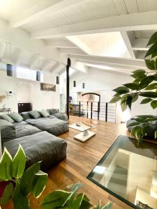 een woonkamer met een bank en een aantal planten bij Luxury industrial apt vicino al centro con garage in Brescia