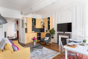 a living room with a couch and a table at Le Pop'Appart - Au cœur du centre historique in Rennes