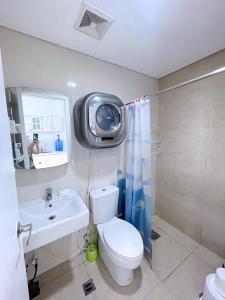 ein Bad mit WC und ein TV an der Wand in der Unterkunft Cebu Aviner(water Front) in Cebu City