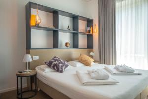 Un dormitorio con una cama grande con almohadas. en Glocal Torbole en Nago-Torbole