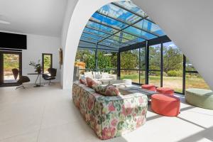una sala de estar con sofá y muchas ventanas en Villa Nandina, en Trans-en-Provence