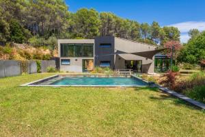 a house with a swimming pool in front of a yard at Villa Nandina in Trans-en-Provence