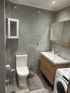 ein Badezimmer mit einem WC, einem Waschbecken und einer Waschmaschine in der Unterkunft Amazing apartment in the center in Thessaloniki